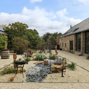 Un jardin zen réunissant la maison principale et les maisons attenantes
